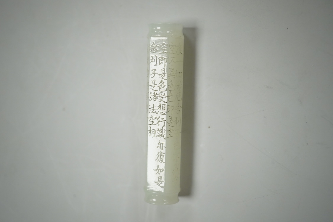 A Chinese pale celadon jade inscribed cylinder bead, 6.5cm long